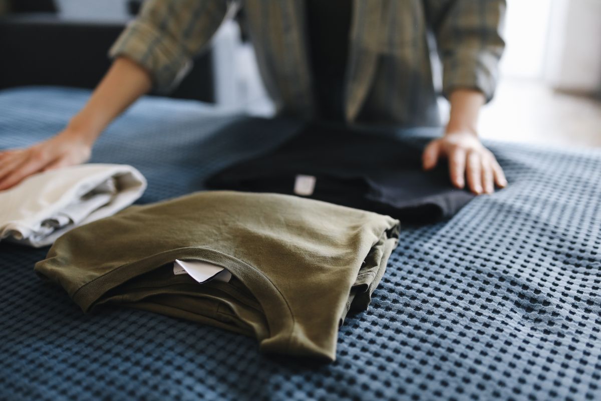 Folded clothes neatly arranged on a bed for plus size clothing care