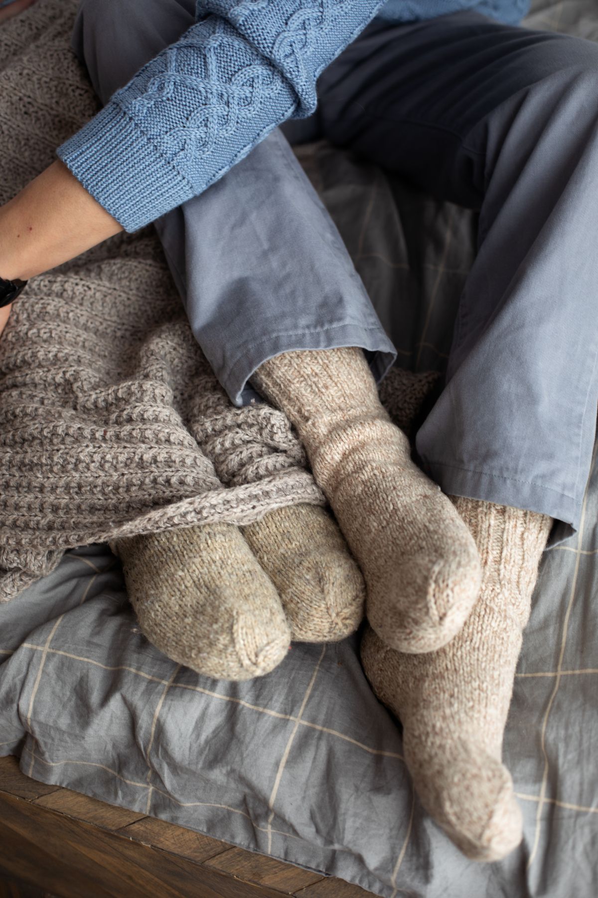 Cozy plus size thermal socks worn on a bed with a warm knitted blanket nearby